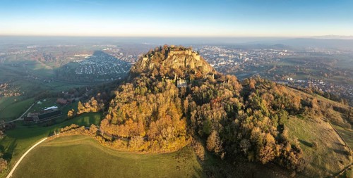 Aerial view, panorama of the Hohentwiel volcanic cone with the castle ruins illuminated by the