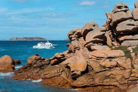 Rocky coast with passing boat and small island on the horizon, Ploumanac'h, Ploumanach,