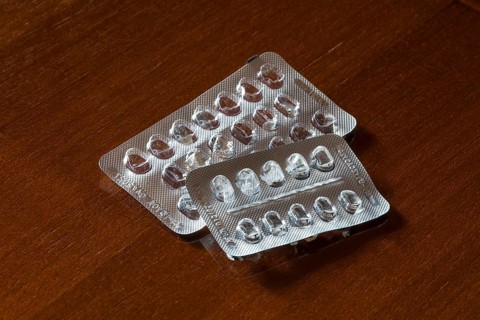 Empty blister packs on a brown wooden surface