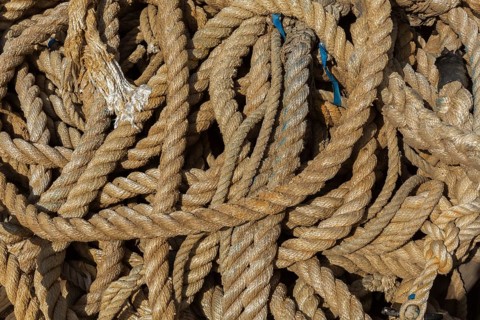 Close-up of old coiled mixed size ropes on the ground, Port of Gruz, Dubrovnik, Croatia, Europe