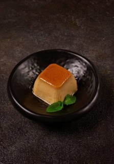 Cream caramel pudding, with caramel sauce, dessert, breakfast, on a black plate, mint, no people
