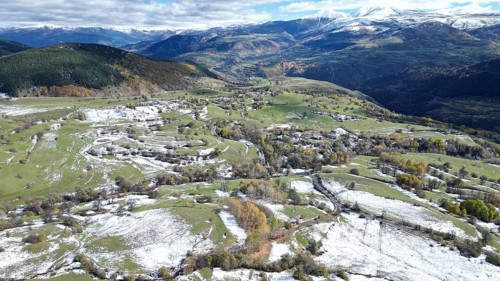 Aerial view of snow-patched fields surrounded by mountains and clouds. Posof, Ardahan, TURKEY