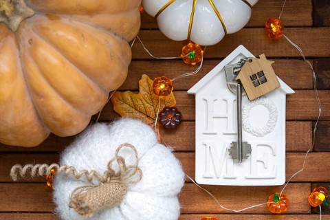 Cozy layout on a wooden background of slats with pumpkins, autumn leaves, a house and keys, autumn