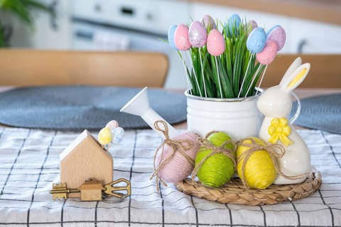 Key to house of cozy home with Easter decor with rabbit and eggs on table of kitchen. Building,