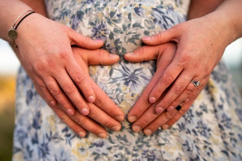 Couple forming a heart on belly bump in Albufeira, Algarve, Portugal, Europe