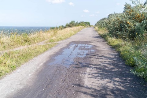 Wide gravel path on a hill with a distant view