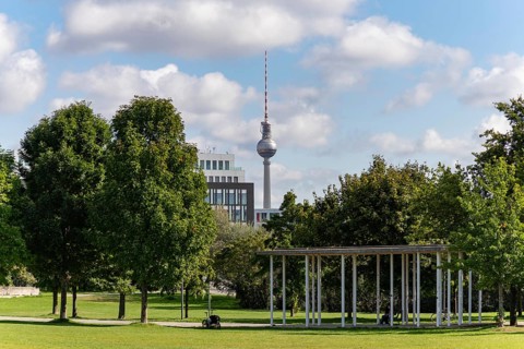 A picture of the Berlin television tower as seen from the Spreebogenpark