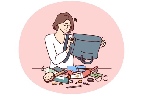 Puzzled woman shakes out contents of bag on table trying to find wallet with money or mobile phone.
