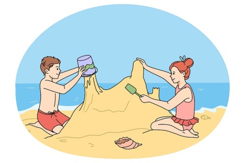 Happy children building sand castle on beach on summer holidays. Smiling little kids play with