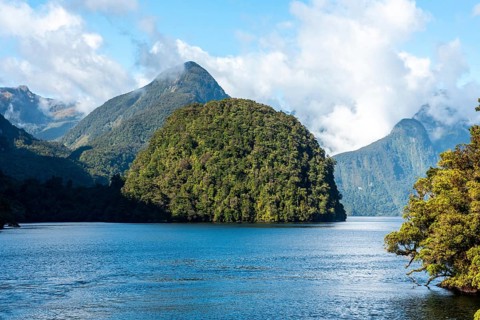 A new morning dawning at Doutful Sound, clouds hanging low in the mountains, South Island of New