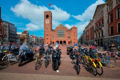 Amsterdam, Netherlands, May 7, 2017: Beursplein with parked bicycles motorcycles and Beurs van