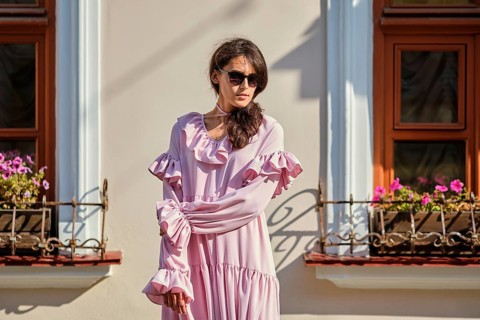 Outdoor urban portrait of young beautiful stylish girl in oversized pink dress