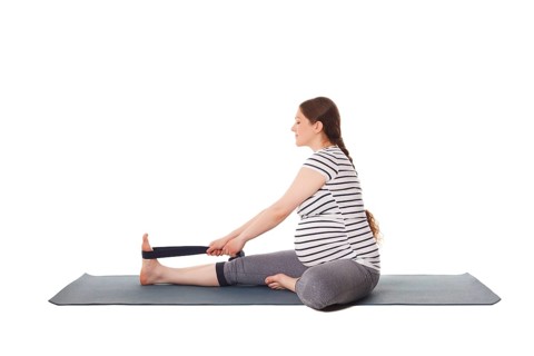Pregnancy yoga exercise, pregnant woman doing yoga asana Janu Sirsasana A Head-to-Knee Forward Bend