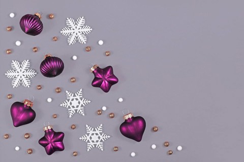 Christmas flat lay with purple heart and star shaped and round tree ornament baubles and white