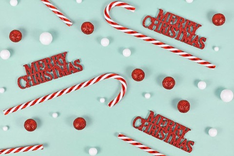 Christmas ornaments with 'Merry Christmas' text, candy canes and snowballs on mint green background