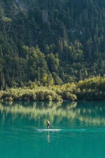 Stand-up paddler on Lake Klöntal, Canton Glarus, Switzerland, Europe