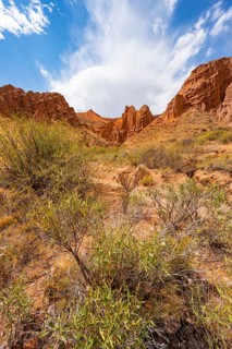 Eroded mountain landscape with sandstone cliffs, canyon with red and orange rock formations,