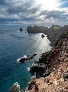 Red cliffs and rocks in the sea, coastal landscape with dramatic sky, Ponta de São Lourenço,