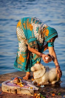 MAHESHWAR, INDIA, APRIL 26: Indian woman performs morning pooja on sacred river Narmada ghats on