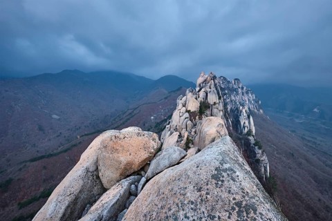 View of stones and rock formations from Ulsanbawi rock peak in stormy weather with clouds.