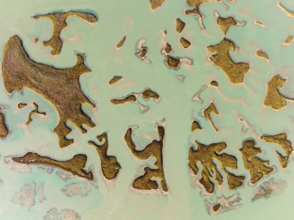 Patches of land appear while the tide is going out, in the marshland of the Bahía de Cádiz, aerial
