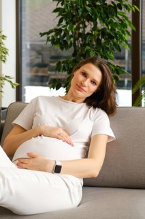 Beautiful pregnant woman having rest on sofa at home