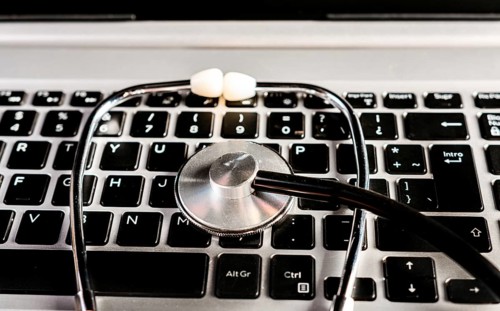 Stethoscope on laptop keyboard. Online medical consultation concept