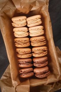 Brown, beige and cream colored French macarons with coffee, mocha, chocolate and vanilla flavor in