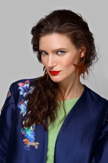 Skeptic lady with natural make-up and brunette hair studio fashion shot on grey background, perfect