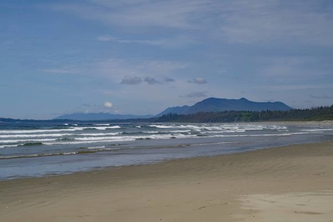 Endless empty sandy beach with swell and mountains in the background, Long Beach, Pacific Rim