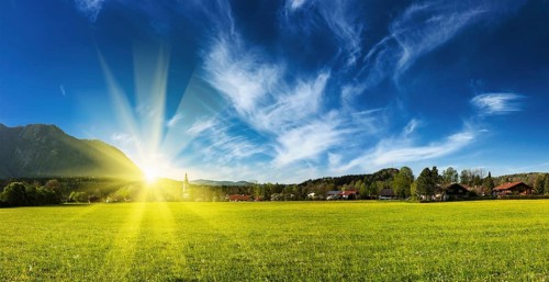 Panorama of German countryside and village on sunset with sun. Bavaria, Germany, Europe