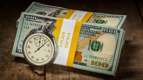 Time is money loan concept background, letterbox panorama of stopwatch and stack of new 100 US