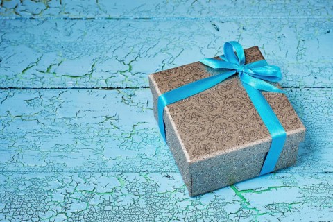 Gift birthday Christmas present concept, silver gift box with blue ribbon on blue painted wooden