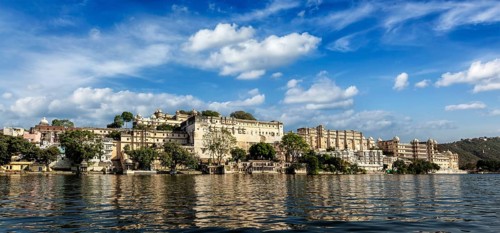 India luxury tourism concept background, panorama of Udaipur City Palace from Lake Pichola.