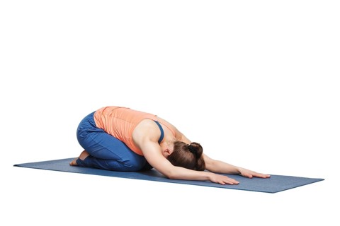 Beautiful sporty fit yogini woman practices yoga asana balasana (child's pose), resting pose or