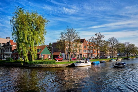 HAARLEM, NETHERLANDS, MAY 6, 2017: Boat in canal and houses. Harlem, Netherlands