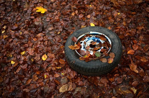 Old car tyre, wheel, rim, lying in autumn leaves, Swabian Forest, Baden-Württemberg, Germany,