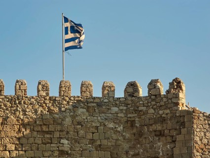 Venetian sea fortress, Koules, Morosini, battlements, Greek national flag, blue cloudless sky,