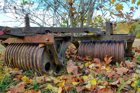 Old rusty agricultural implement in the shape of a field roller
