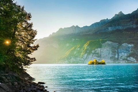 Last light over Lake Walen with the small chive island in the turquoise water and mountain range