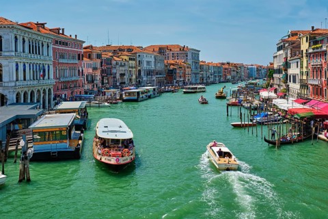 VENICE, ITALY, JULY 19, 2019: Grand Canal with boats, vaporetto and gondolas on sunset from Rialto