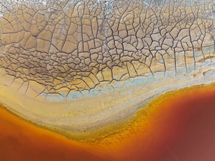 Cracked earth at the bank of the Rio Tinto (Red river) with its deep reddish hue due to oxidised