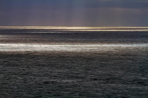 Sunbeams through cloud cover, sunlight glistening on the sea, evening sky, motion blur,