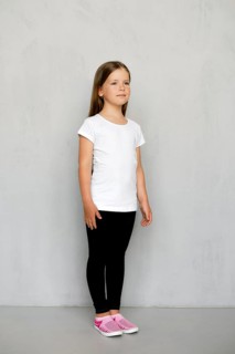 Cute young child with long hair in white t-shirt and black sweatpants posing