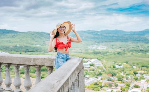 Portrait of beautiful tourist girl in a viewpoint. Happy vacationer woman in hat on a viewpoint.