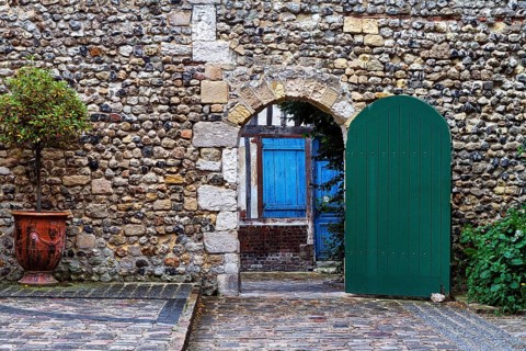 View through gate with green door on traditional stone house with blue door, Old Town, Honfleur,