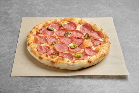 Spicy pizza with sausage and pickled jalapeno pepper on parchment