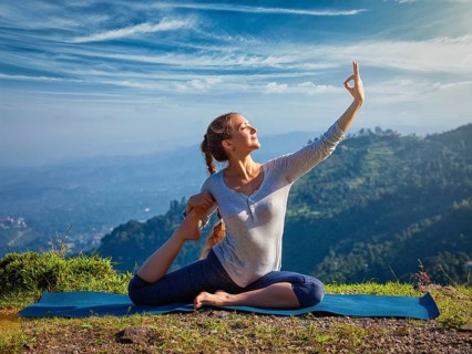 Yoga outdoors, young sporty fit woman doing stretching yoga asana Eka pada rajakapotasana,