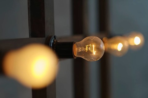 Old edison lamp mounted on wooden background