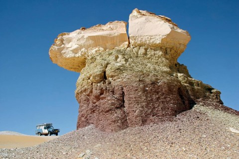 Four-wheel drive vehicle and limestone rock formation in Egypt's White Desert, Sahara el Beyda near